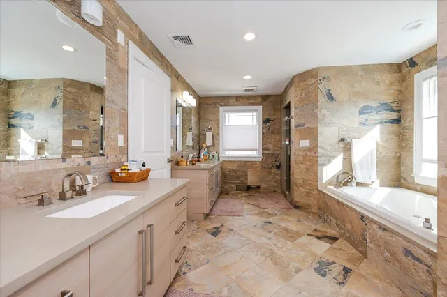 a spacious bathroom with a sink mirror and a bath tub