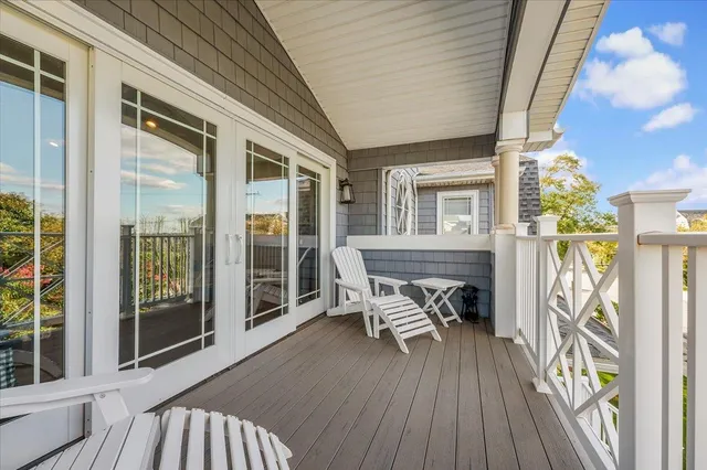 a balcony with wooden floor table and chairs
