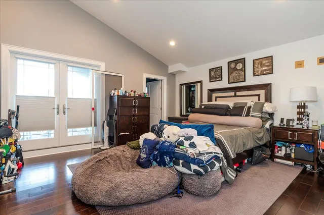 a bedroom with bed and wooden floor