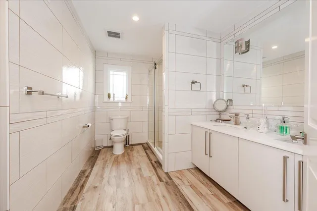 a bathroom with a sink a toilet and shower