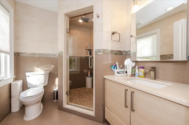a bathroom with a toilet a sink and glass door