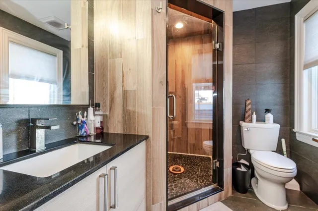 a bathroom with a granite countertop sink toilet and shower