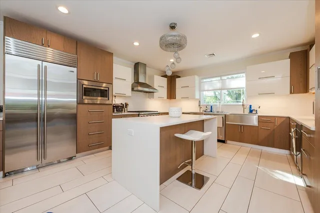 a kitchen with kitchen island a counter top space appliances and a cabinets