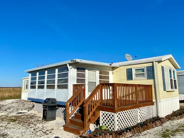 a view of a house with a wooden deck and a yard