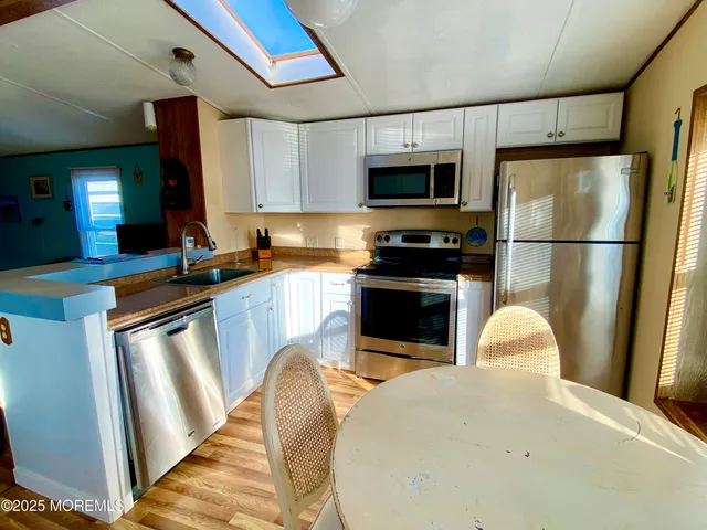 a kitchen with stainless steel appliances granite countertop a sink a stove and a refrigerator