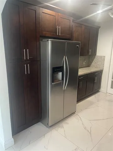 a metallic refrigerator freezer sitting in a kitchen
