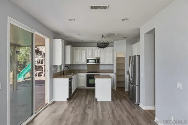 a kitchen with stainless steel appliances a refrigerator a stove top oven and sink