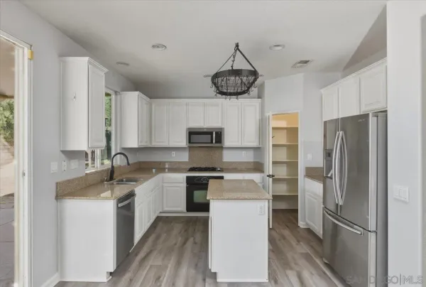 a kitchen with stainless steel appliances a sink stove and refrigerator