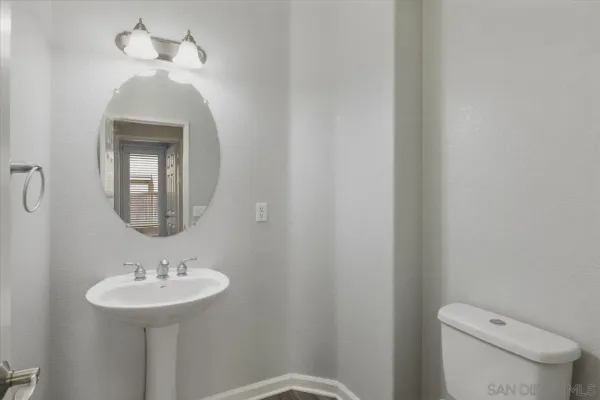 a bathroom with a toilet a sink and mirror