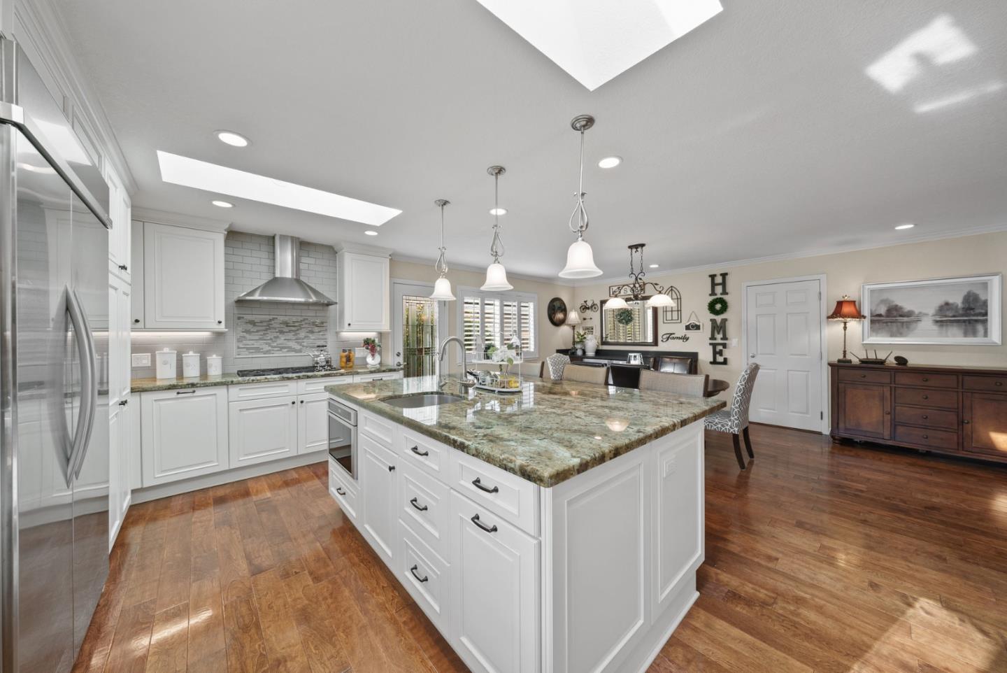1664 Corte De Pons San Jose, CA 95124 - Photo 9 of 39 a kitchen with stainless steel appliances granite countertop a kitchen island a stove a sink a refrigerator and white cabinets with wooden floor