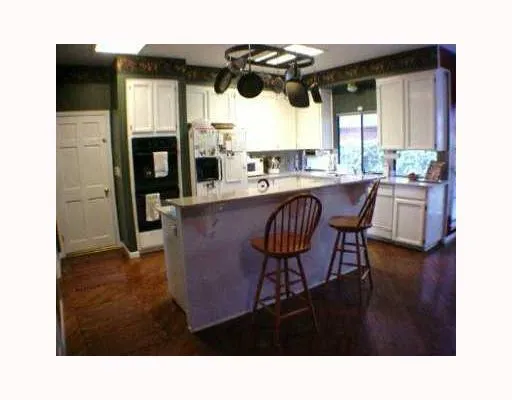 a kitchen with a table chairs and a wooden floor