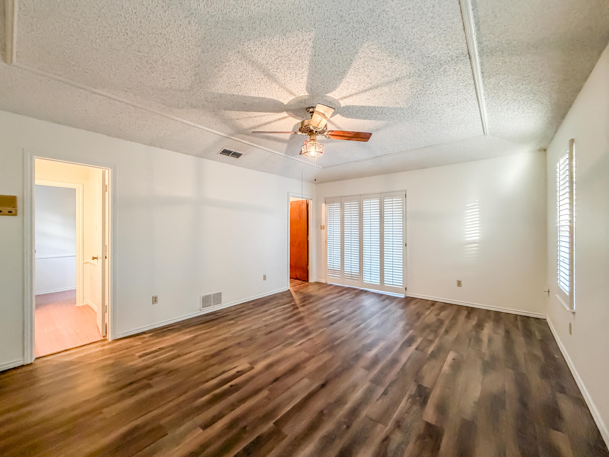 3503 91st Street Lubbock, TX 79423 - Photo 14 of 23 a view of an empty room with window and wooden floor