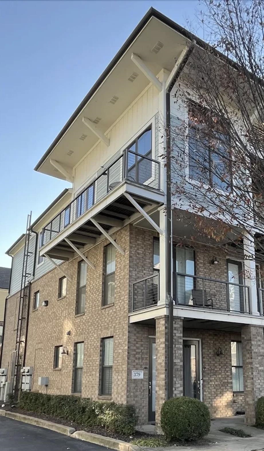 View of corner unit condominium with two balconies and amazing curb appeal