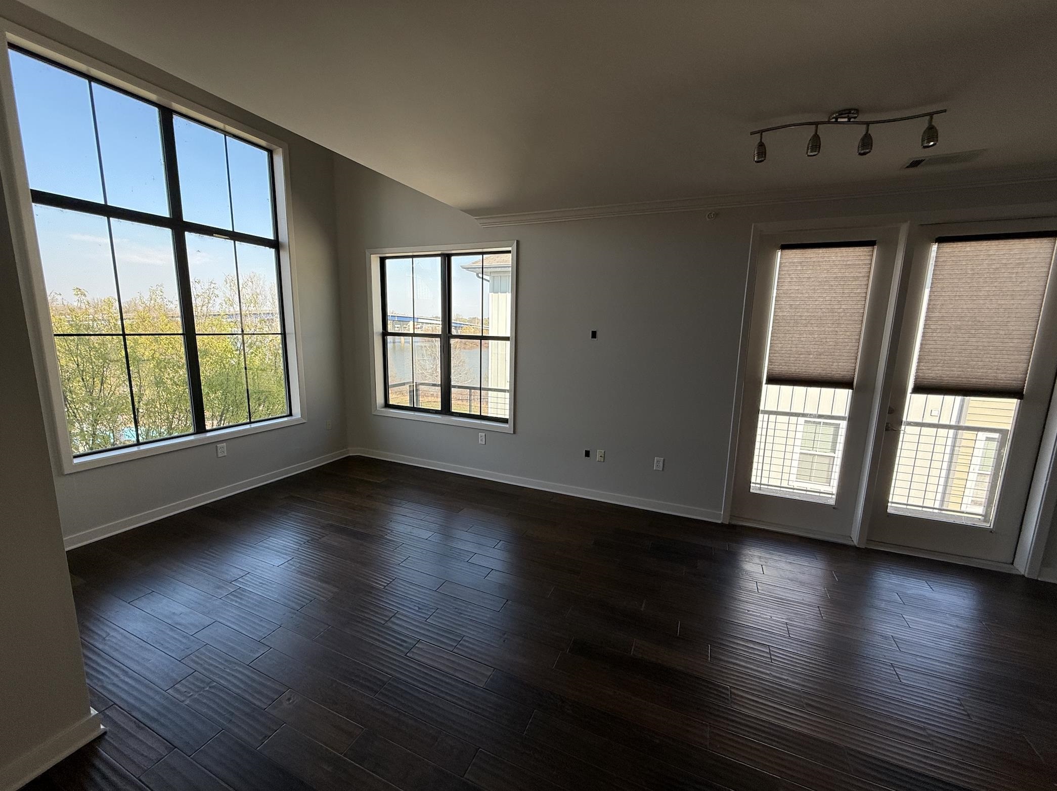 379 Cobalt Bay Loop, Unit 304 Memphis, TN 38103 - Photo 5 of 24 a view of an empty room with wooden floor and a window