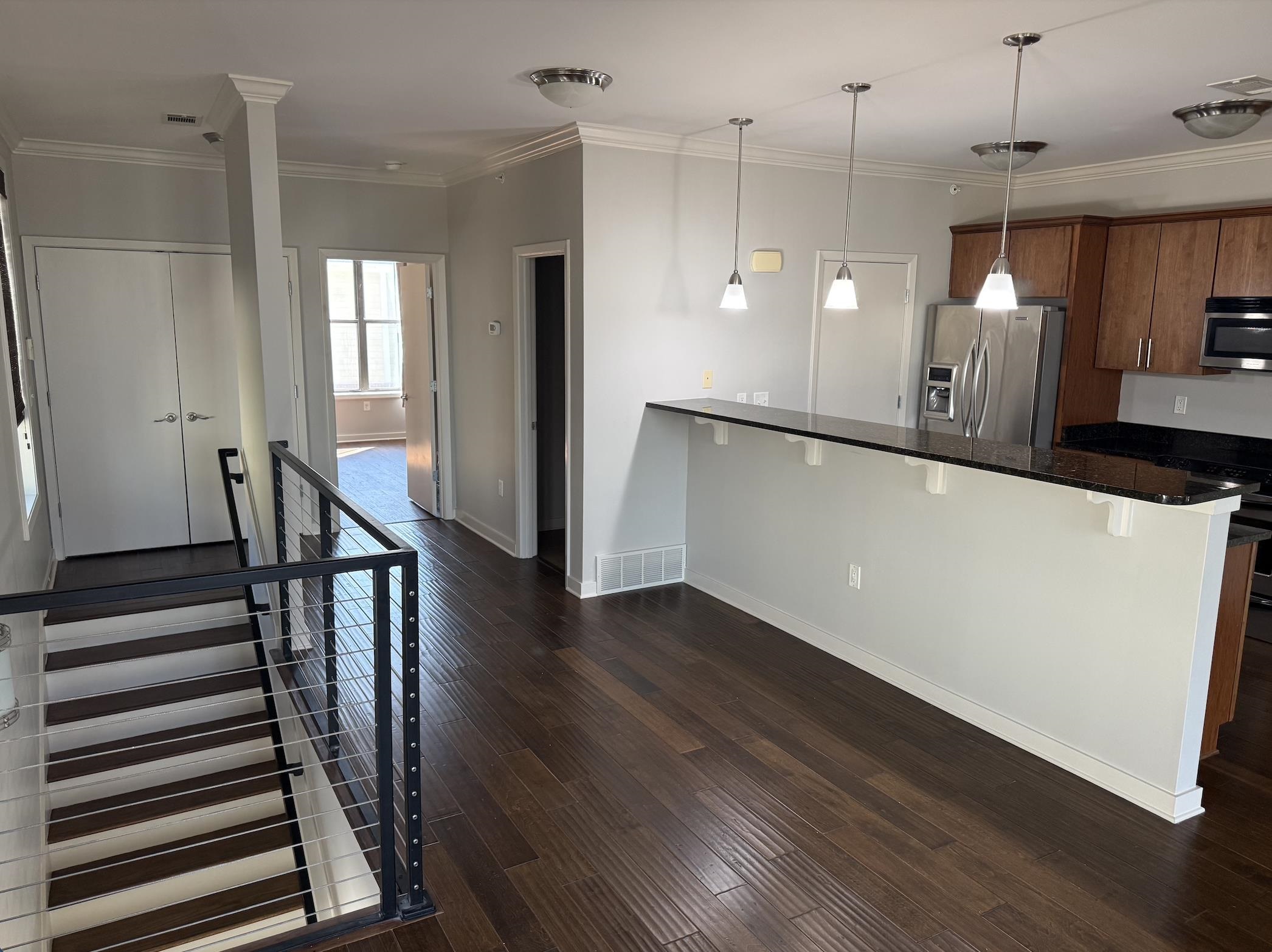379 Cobalt Bay Loop, Unit 304 Memphis, TN 38103 - Photo 6 of 24 Kitchen with stainless steel appliances, breakfast bar area, wood finish cabinets, and wood flooring