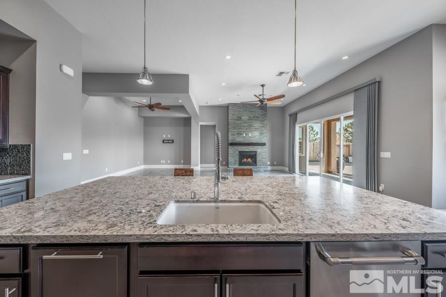9405 Stony Hill Road Reno, NV 89521 - Photo 12 of 37 a kitchen with kitchen island granite countertop a counter space windows and appliances