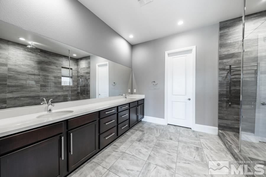 9405 Stony Hill Road Reno, NV 89521 - Photo 19 of 37 a spacious bathroom with a double vanity sink a mirror and a shower