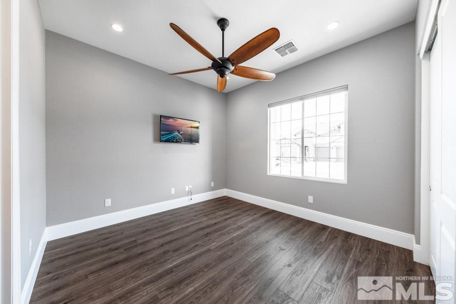 9405 Stony Hill Road Reno, NV 89521 - Photo 24 of 37 an empty room with wooden floor a ceiling fan and windows
