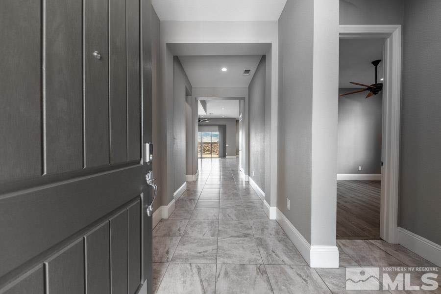 9405 Stony Hill Road Reno, NV 89521 - Photo 4 of 37 a view of a hallway with wooden floor and a bathroom