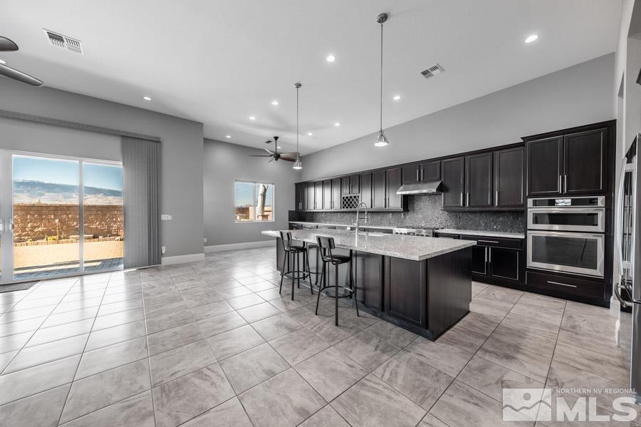 9405 Stony Hill Road Reno, NV 89521 - Photo 7 of 37 a kitchen with stainless steel appliances granite countertop a stove top oven a sink a counter top space and cabinets