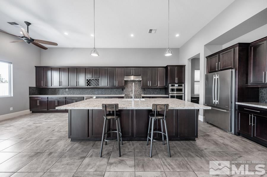 9405 Stony Hill Road Reno, NV 89521 - Photo 8 of 37 a kitchen with a dining table chairs and refrigerator