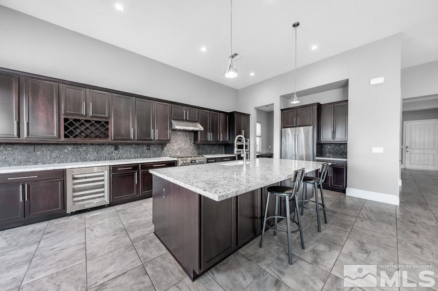 9405 Stony Hill Road Reno, NV 89521 - Photo 9 of 37 a kitchen with kitchen island granite countertop a stove top oven a sink a dining table and chairs