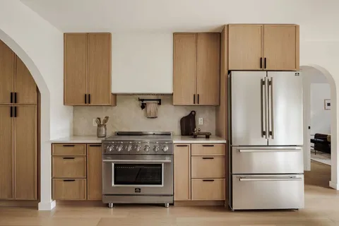 a kitchen with refrigerator a stove and wooden cabinets