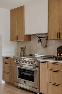 a kitchen with granite countertop a stove and a white cabinets