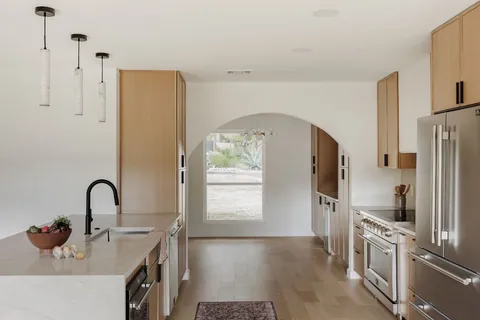 a kitchen with stainless steel appliances a refrigerator a sink a stove and a refrigerator