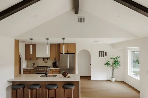 a view of kitchen with kitchen island stainless steel appliances refrigerator sink and cabinets
