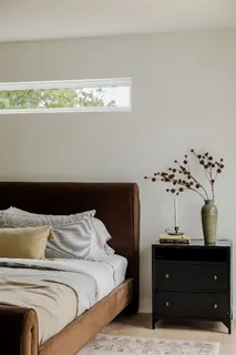 a bedroom with a bed and a potted plant