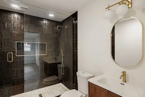 a bathroom with a sink a toilet and shower