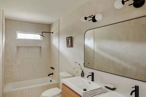 a bathroom with a sink vanity granite tub and shower