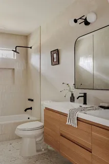 a bathroom with a bathtub shower sink vanity and toilet
