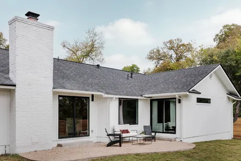 a view of a house with backyard and sitting area