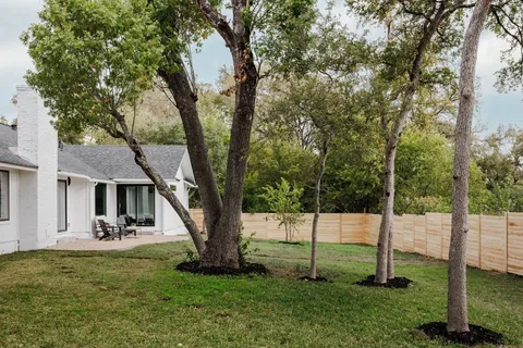 a view of a house with backyard and a tree