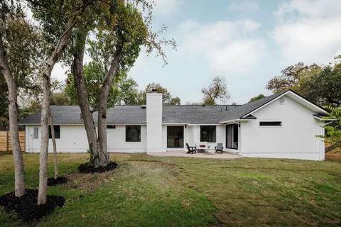a front view of house with yard and trees around