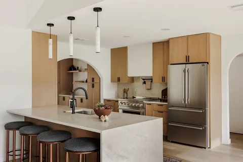 a kitchen with stainless steel appliances a refrigerator a sink a stove and a center island