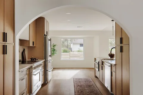 a kitchen with stainless steel appliances a stove a sink and a refrigerator