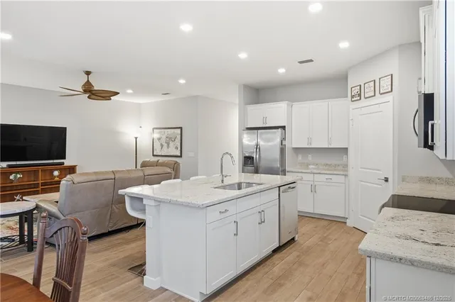 a living room with furniture and a dining table with wooden floor