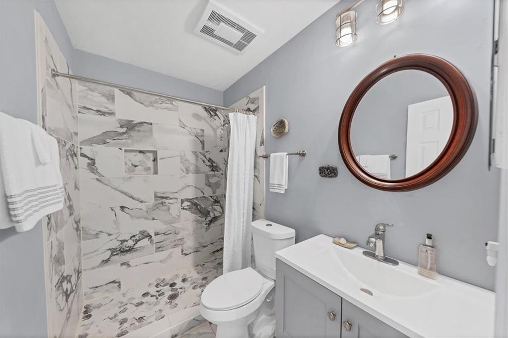 45 Forrest Place Northeast Atlanta, GA 30328 - Photo 29 of 51 a bathroom with a sink a toilet and a mirror