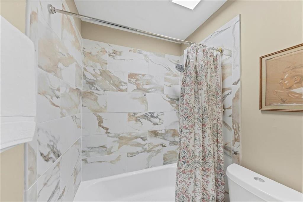 45 Forrest Place Northeast Atlanta, GA 30328 - Photo 36 of 51 a bathroom with a shower curtain and a toilet