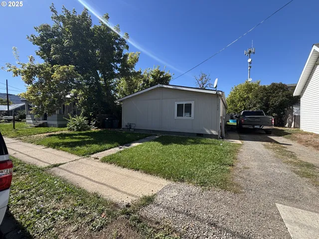 a view of a white house with a yard