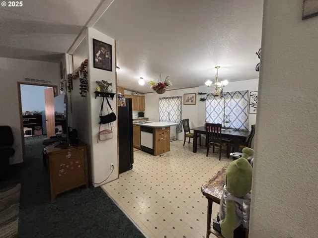 a living room with furniture a chandelier and kitchen view