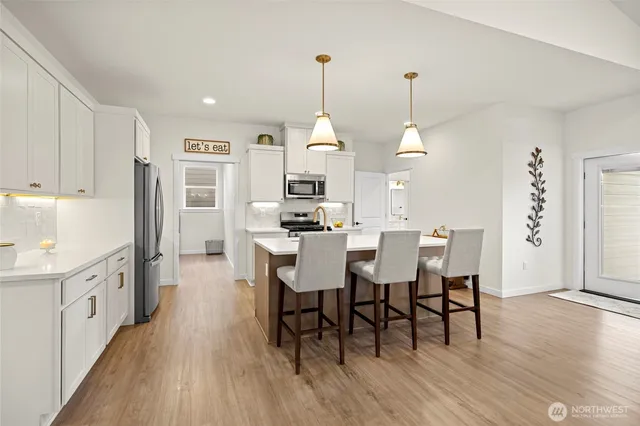 a dining room with furniture a chandelier and wooden floor