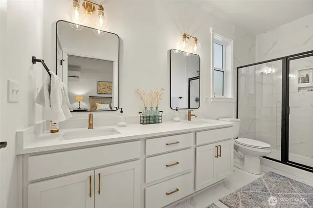 a bathroom with a double vanity sink mirror and toilet