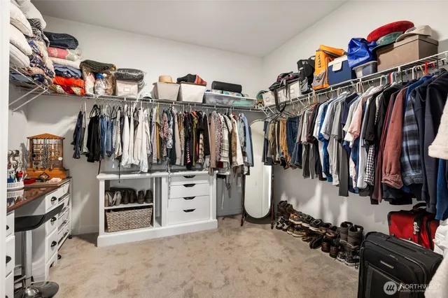 a view of walk in closet with clothes and shoes