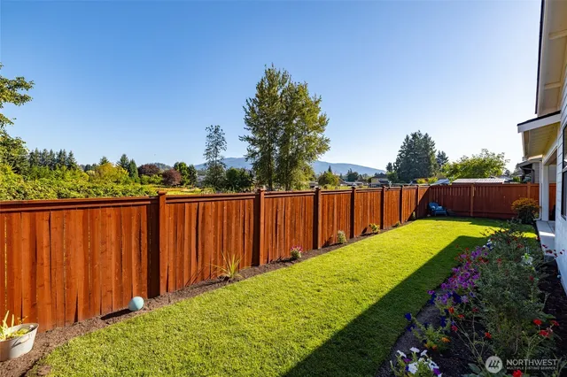 a view of a backyard with wooden fence