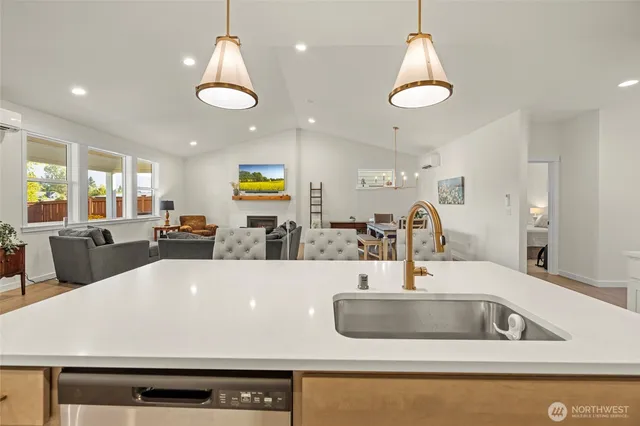 a large kitchen with a large counter space a sink and chandelier