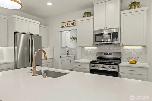 a kitchen with stainless steel appliances a stove a sink and a refrigerator